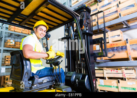 Asiatische Gabelstapler LKW Fahrer heben Palette in Lagerhalle Stockfoto