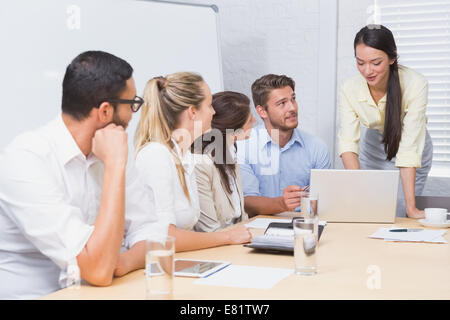 Geschäftsleute, die eine Frau dabei eine Präsentation zuhören Stockfoto