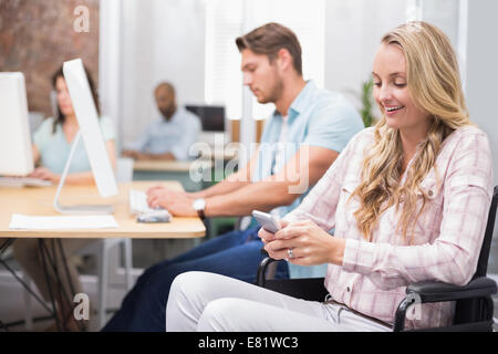 Geschäftsfrau im Rollstuhl SMS auf Handy Stockfoto