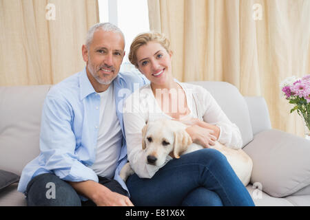 Brautpaar mit Welpen auf Sofa kuscheln Stockfoto