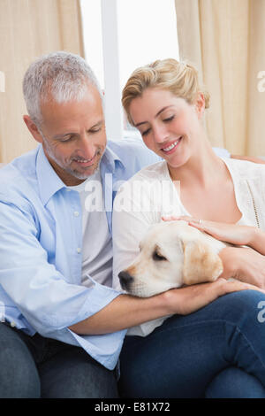 Brautpaar mit Welpen auf Sofa kuscheln Stockfoto