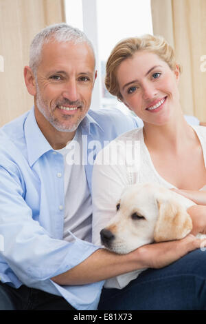 Brautpaar mit Welpen auf Sofa kuscheln Stockfoto