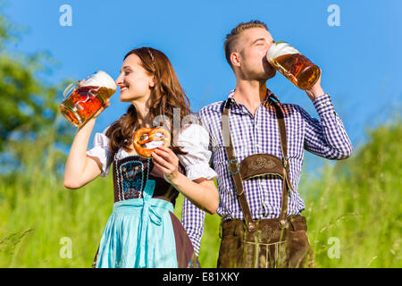 Deutsches Paar in Tracht mit Bier und Brezel Stockfoto