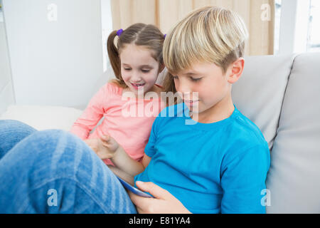 Glücklich Geschwister mit Tablet-pc auf sofa Stockfoto
