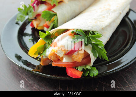 Tortilla-Wraps mit frischem Huhn und Gemüse auf einem Teller Stockfoto