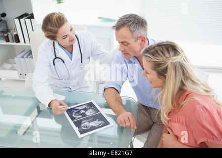 Glückliches Paar Rücksprache mit Arzt Stockfoto
