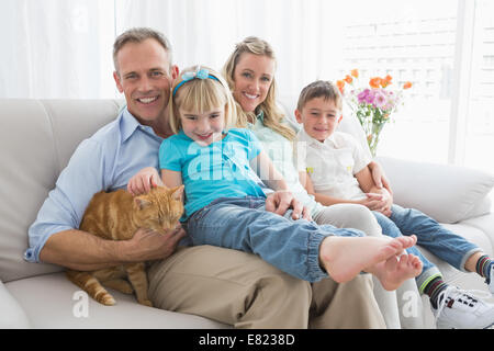 Nette Familie Entspannung zusammen auf der Couch mit ihrer Katze Stockfoto