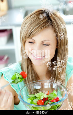 Junge Frau in der Küche einen Salat zu essen Stockfoto