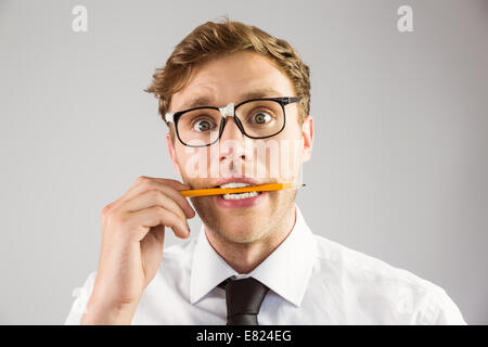 Geeky Geschäftsmann beißen einen Bleistift Stockfoto
