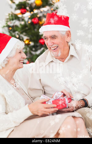 Älteres Ehepaar, die Austausch von Weihnachtsgeschenke Stockfoto