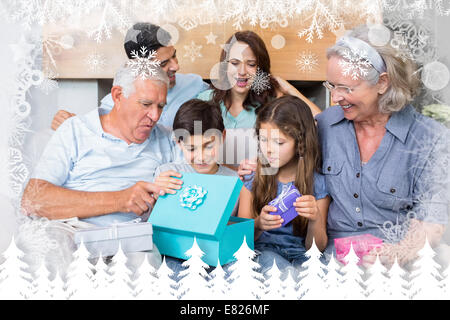 Zusammengesetztes Bild der Großfamilie auf Sofa mit Geschenk-Boxen im Wohnzimmer sitzen Stockfoto