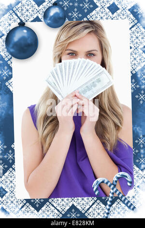 Blonde Frau verbirgt ihr Gesicht hinter ein Fan von Notizen Stockfoto