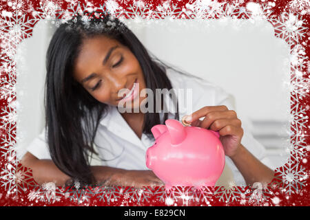 Lächeln, Geschäftsfrau, Münzen in die Piggy Bank an ihrem Schreibtisch Stockfoto