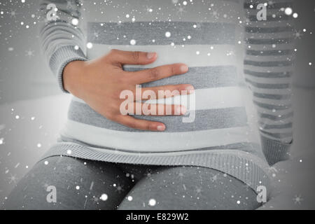 Innenfeldes von einer Frau mit Magenschmerzen im Bett sitzen Stockfoto