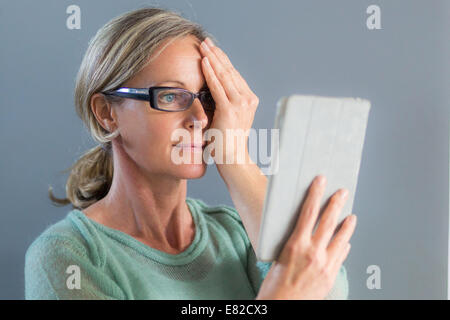 Ältere Frau betrachten ein Amsler-Gitters, Makula-Degeneration zu erkennen. Stockfoto