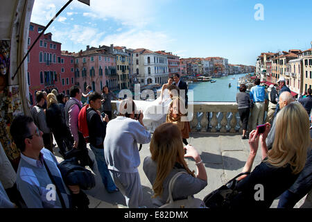 Frisch verheiratet asiatische Paare, die ihre Hochzeitsfotos, die auf der Rialto-Brücke, Venedig, Italien, mit Canal Grande als Kulisse. Stockfoto