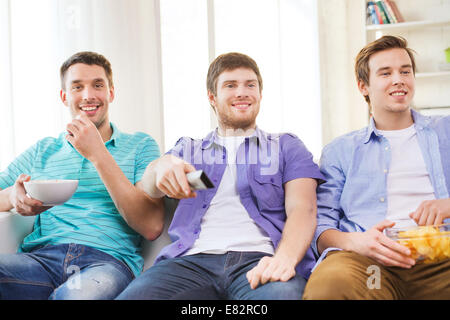 glücklich männlichen Freunden vor dem Fernseher zu Hause Stockfoto