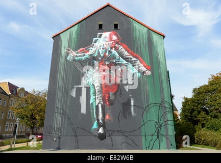 Lutherstadt Wittenberg, Deutschland. 29. Sep, 2014. Die Graffiti "Springen zur Freiheit" zeigt den Sprung des Soldaten Conrad Schumann während des Baus der Berliner Mauer in Lutherstadt Wittenberg, Deutschland, 29. September 2014. Das Graffiti ist Teil des Projekts "Kura", Stadtraum Kunst und Stadtentwicklung der Stadt Wittenberg. Bildnachweis: Dpa picture Alliance/Alamy Live News Stockfoto