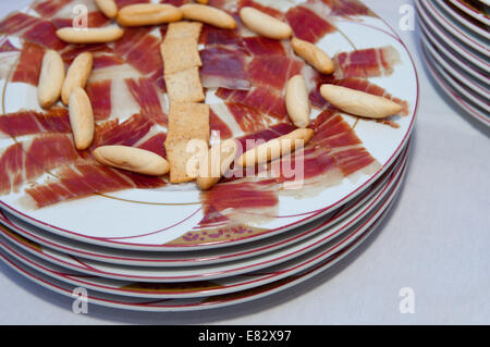 Nahaufnahme einer Platte mit Scheiben Schinken und einige Picos, Grissini über Stockfoto