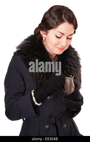 Luxus-Frau in einem schwarzen Mantel sieht in einer leeren Brieftasche Stockfoto