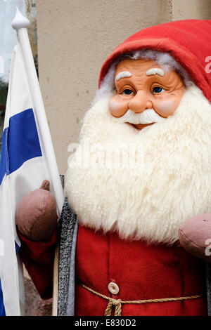 Finnland, Helsinki. Nahaufnahme einer Weihnachtsmann-Puppe mit der finnischen nationalen Flagge Stockfoto