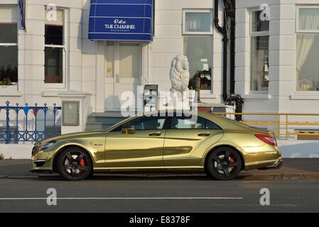 Gold lackierte Mercedes Benz Sport-Limousine auf Eastbourne Strandpromenade geparkt Stockfoto