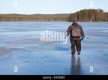 Isolierter älterer Mann, der in Spring, Finnland, Eisfischen geht Stockfoto