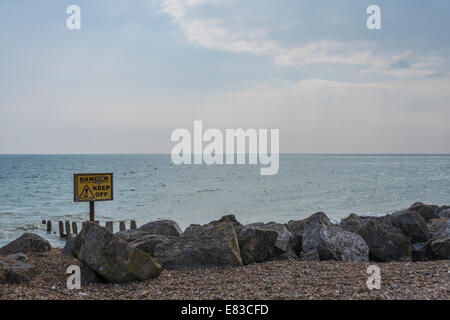 Halten Sie Gefahrenzeichen auf Felsen am Strand Stockfoto