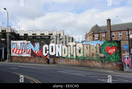 Bedingungslose Liebe Graffiti an der Wand in Providence Ort Brighton UK Person vorbeigehen Stockfoto