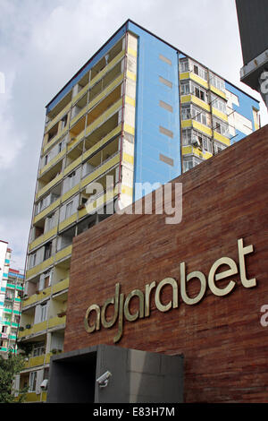 Der Eingang in das Adjarabet Casino in Batumi, Georgien, mit einem alten Wohnblock im Hintergrund. Stockfoto