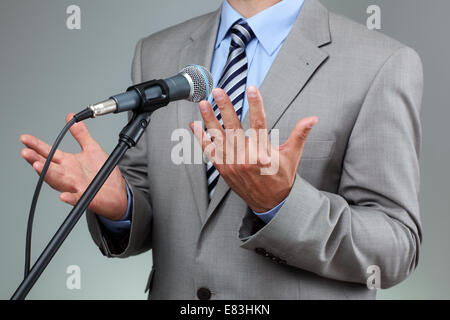 Rede mit Mikrofon und Hand Geste Stockfoto