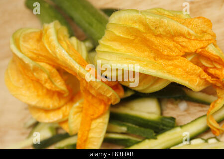 in Scheiben geschnittenen Zucchini mit Blumen auf dem Schneidebrett Cucurbita Pepo befestigen Stockfoto