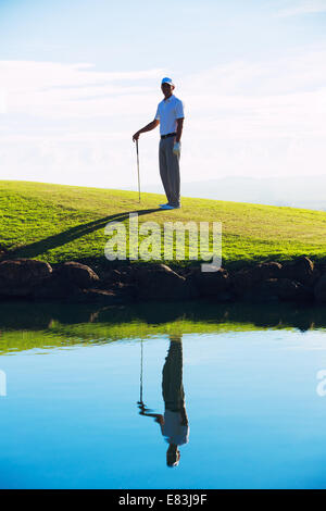 Silhouette der Mann spielt Golf auf wunderschönen Platz, Spiegelung im Wasser Stockfoto