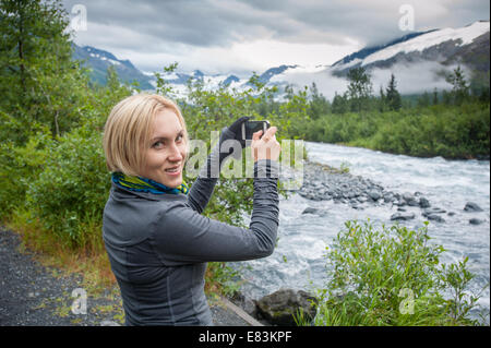 Frau mit iPhone Smartphone in Alaska Stockfoto