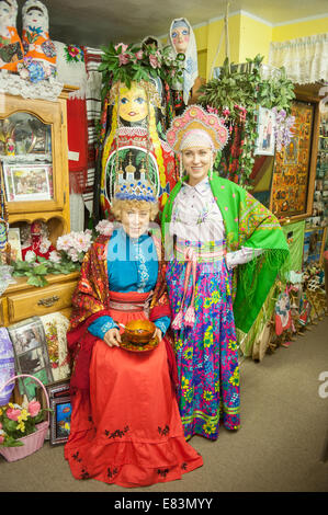 Russisches Alaska - Nikolaevsk AK Menschen tragen russische Tracht im Souvenirladen. Stockfoto