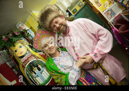 Russisches Alaska - Nikolaevsk AK Menschen tragen russische Tracht im Souvenirladen. Stockfoto