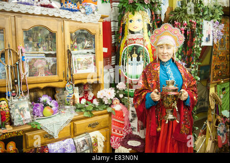 Russisches Alaska - Nikolaevsk AK Menschen tragen russische Tracht im Souvenirladen. Stockfoto