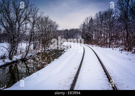 Schneebedeckten Eisenbahnschienen und Creek im ländlichen Carroll County, Maryland. Stockfoto
