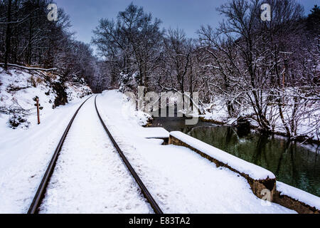 Verschneite Bahngleis und Creek im ländlichen Carroll County, Maryland. Stockfoto
