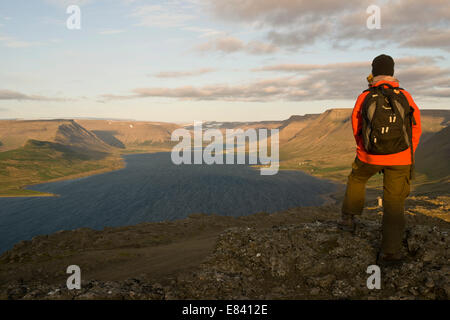Frau auf der Suche über Dýrafjördur Fjord, Westfjorde, Island Stockfoto