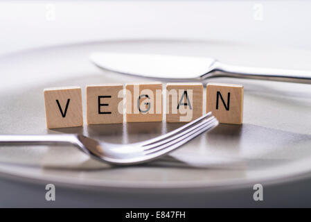 Teller mit Messer und Gabel und das Wort "Vegan". Stockfoto