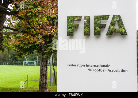 Nahaufnahme des Zeichens vor FIFA-Hauptsitz in Zürich, mit Torpfosten im Hintergrund, Blätter spiegelt sich in den glänzenden Schriftzug Stockfoto