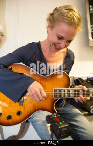 Sänger und Gitarrist Kristin Hersh von Throwing Muses Stimmen ihrer Gitarre hinter den Kulissen. Stockfoto