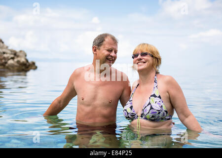 Älteres Paar genießt den Ruhestand auf einem wunderbaren, haben ein erfrischendes Bad im Meer, Lachen Togther, aktiv bleiben und positive Stockfoto