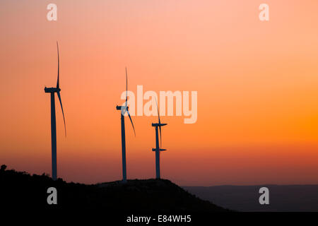 Wind-Turbinen-Silhouette auf dem Berg bei Sonnenuntergang Stockfoto