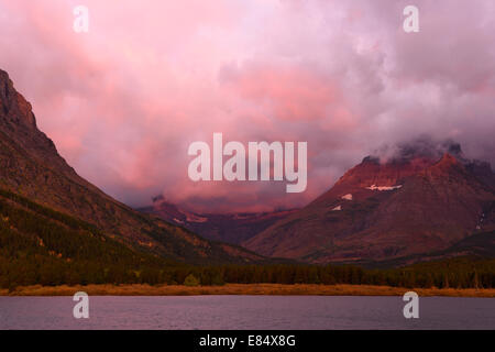 Sonnenaufgang von der Many Glacier Hotel Swiftcurrent Lake im Glacier National Park, Montana. Grinnell Point ist auf der linken Seite. Stockfoto