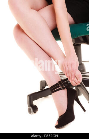Arbeitseinstellung und Schmerzen in den Beinen. Nahaufnahme der müde Geschäftsfrau Frau auf Stuhl sitzend und massiert Füße isoliert auf weiss. Stockfoto
