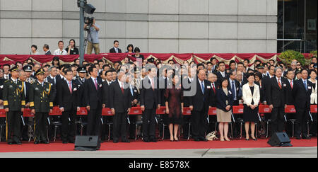 (141001) - HONG KONG, 1. Oktober 2014 (Xinhua)--Tung Chee-Hwa (5. L, vorn), stellvertretender Vorsitzender des Nationalkomitees der politischen Konsultativkonferenz und ehemalige Vorstandsvorsitzende der Hong Kong, Hong Kong Hauptgeschäftsführer Leung Chun-Ying das chinesische Volk (6. L, vorn), Zhang Xiaoming (4. L, vorn), Leiter des Verbindungsbüros der zentralen Volksregierung in Hong Kong und Song Zhe (3. L Front), der Kommissar des Ministry of Foreign Affairs of China in Hong Kong spezielle Administrative Region (SAR), besuchen eine Fahne, die Erhöhung der Zeremonie anlässlich des 65. Jahrestages der Gründung o Stockfoto