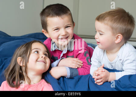 Junge Geschwister gemeinsam entspannen auf Bett Stockfoto