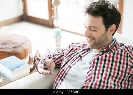 Mann mit Smartphone zu Hause Stockfoto